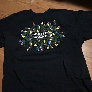 Black shirt with “lighting engineer” print on